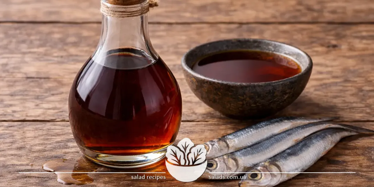 Bouteille de sauce de poisson à côté d’un petit bol de sauce et d’anchois